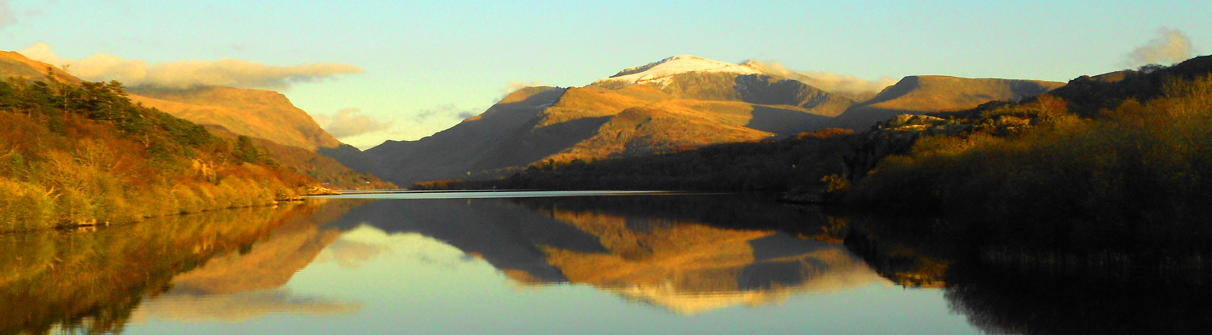 Snow-capped mountains reflected in Llyn Padarn in Eryri